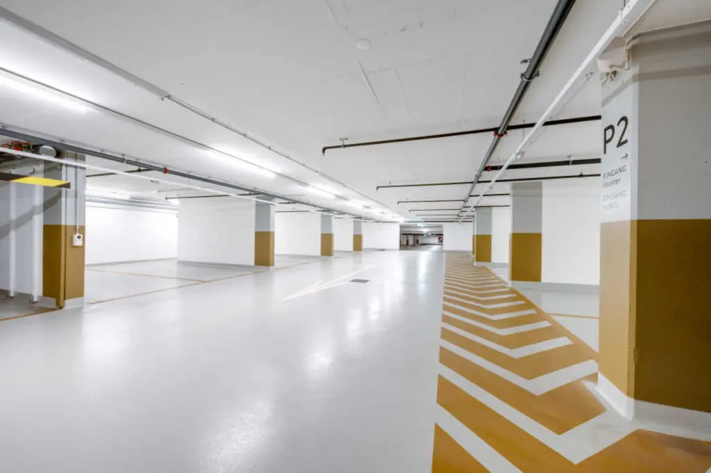 Tiefgarage des Einkaufszentrums Illuster mit markierten Fahr- und Gehflächen.