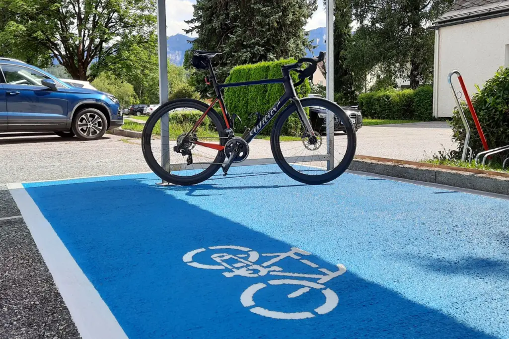 Rennrad auf blau beschichtetem StoPma-Stellplatz mit Fahrradsymbol.