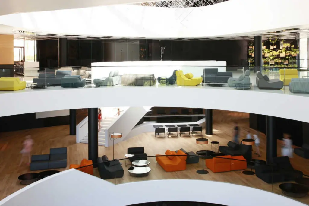 Modernes, zweigeschossiges Lobby-Atrium mit farbigen Loungemöbeln