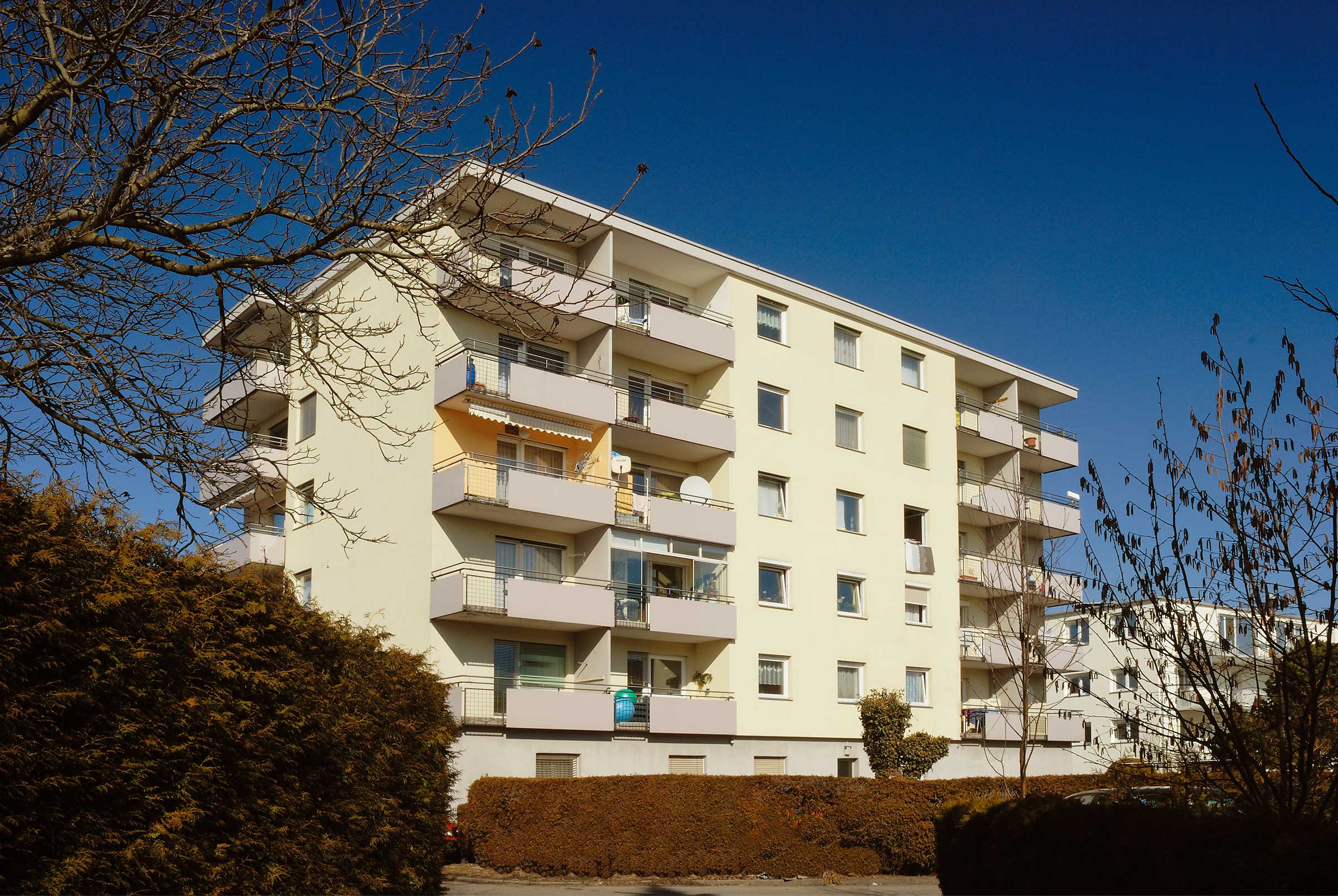 Außenaufnahme eines Mehrfamilienhauses in Österreich, beige Fassade mit EPS-Dämmung von Sto