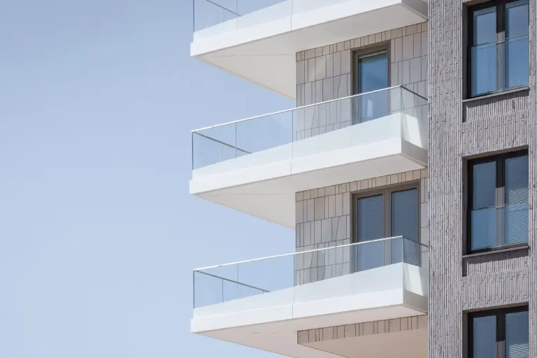 Hotel-Fassade aus vertikal verlegten Klinkerriemchen, ergänzt durch Balkone mit bedruckten Glasbrüstungen