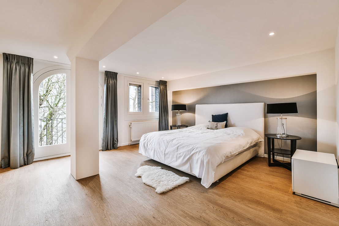 Räume optisch verkleinern - großes Schlafzimmer mit grauer Wand