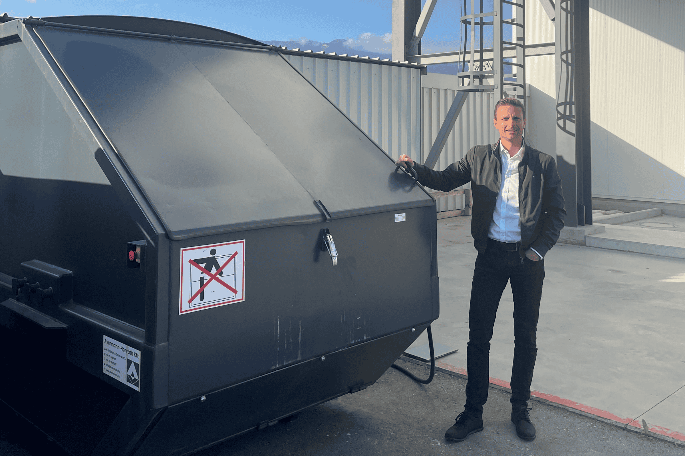 Daniel Rumbold vor Recyclingcontainer für Sto-Verpackungen.